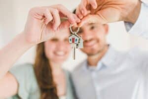A young couple holding the keys to their new home